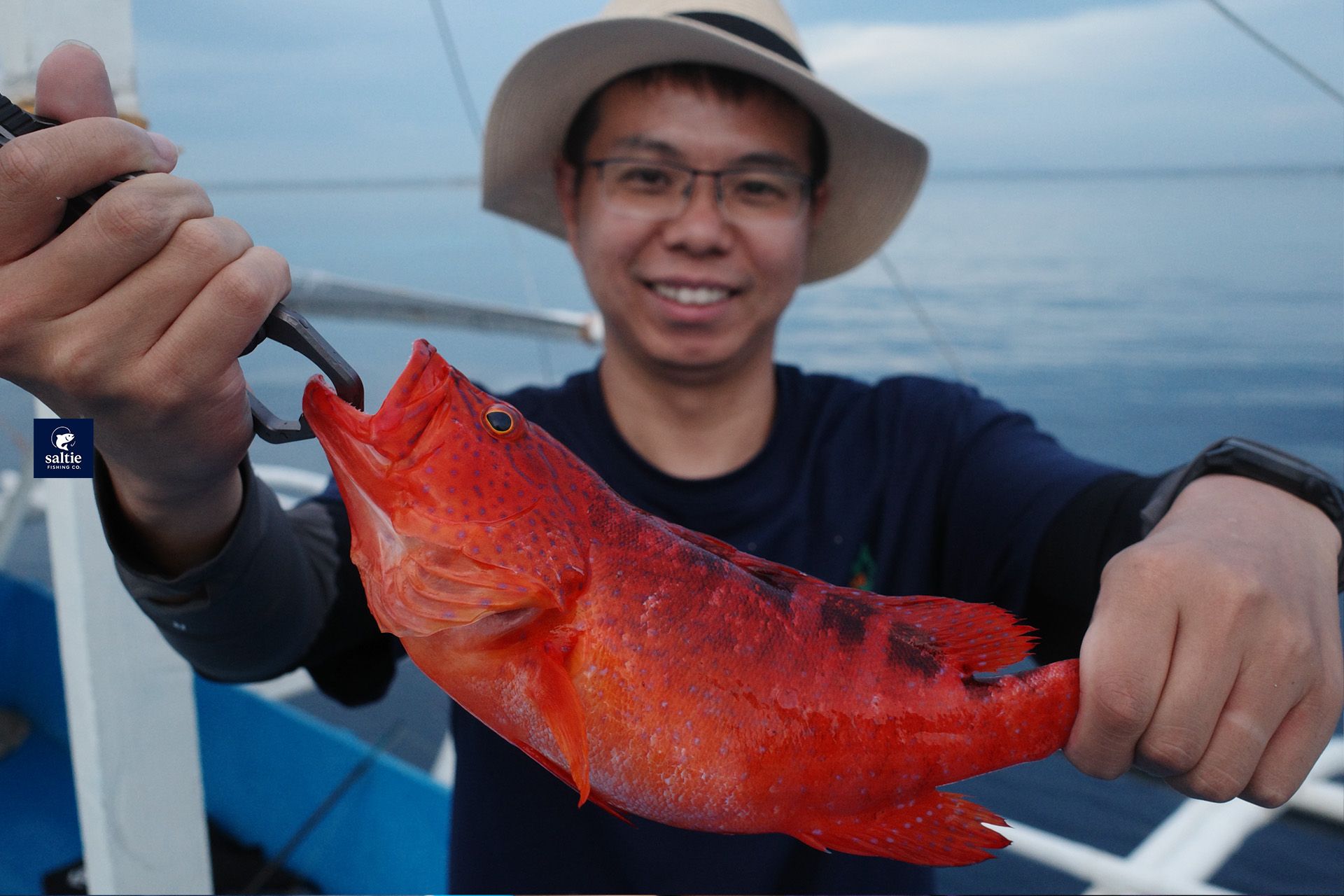 A guest holding a red fish.