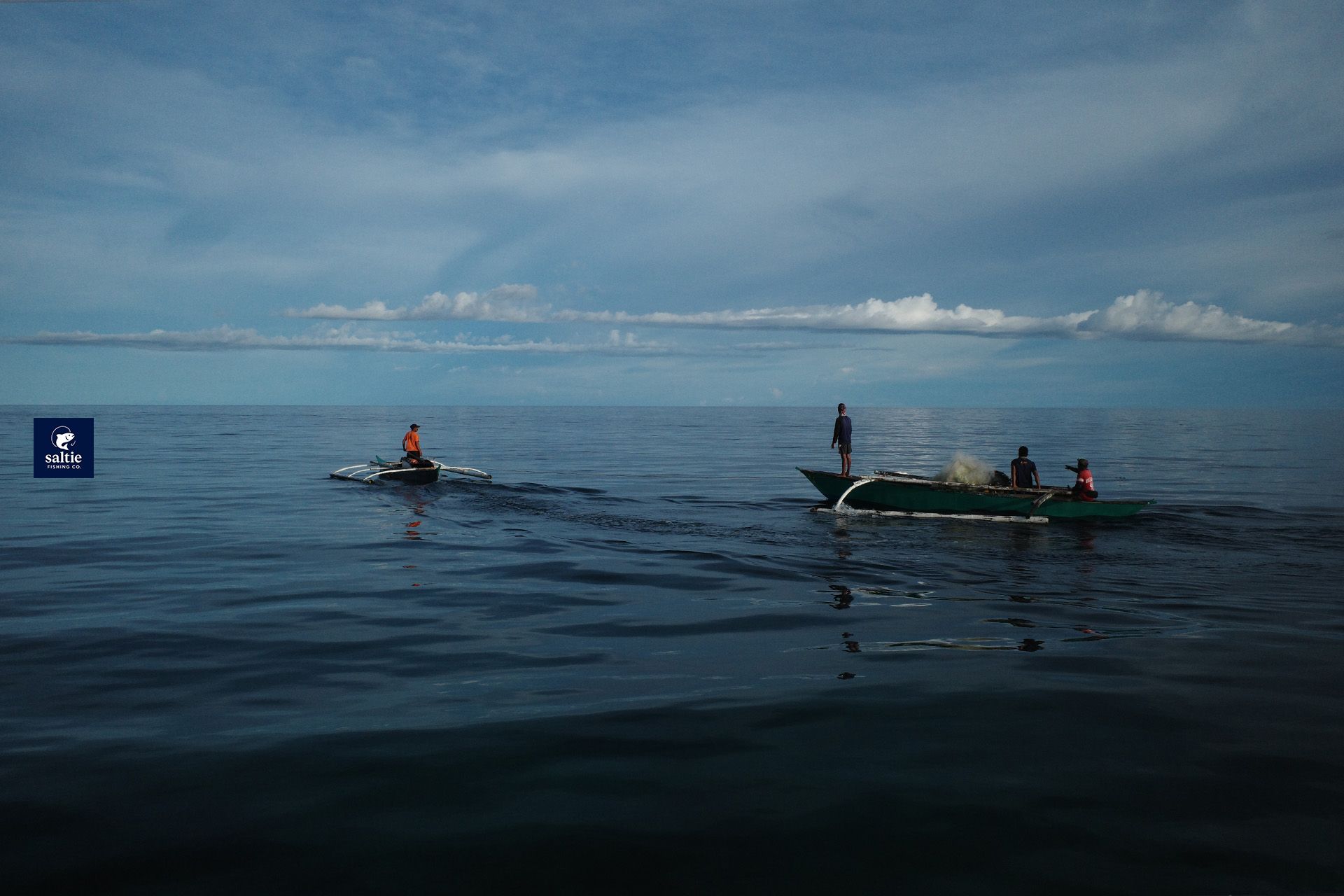 Two small outrigger boats on calm open water