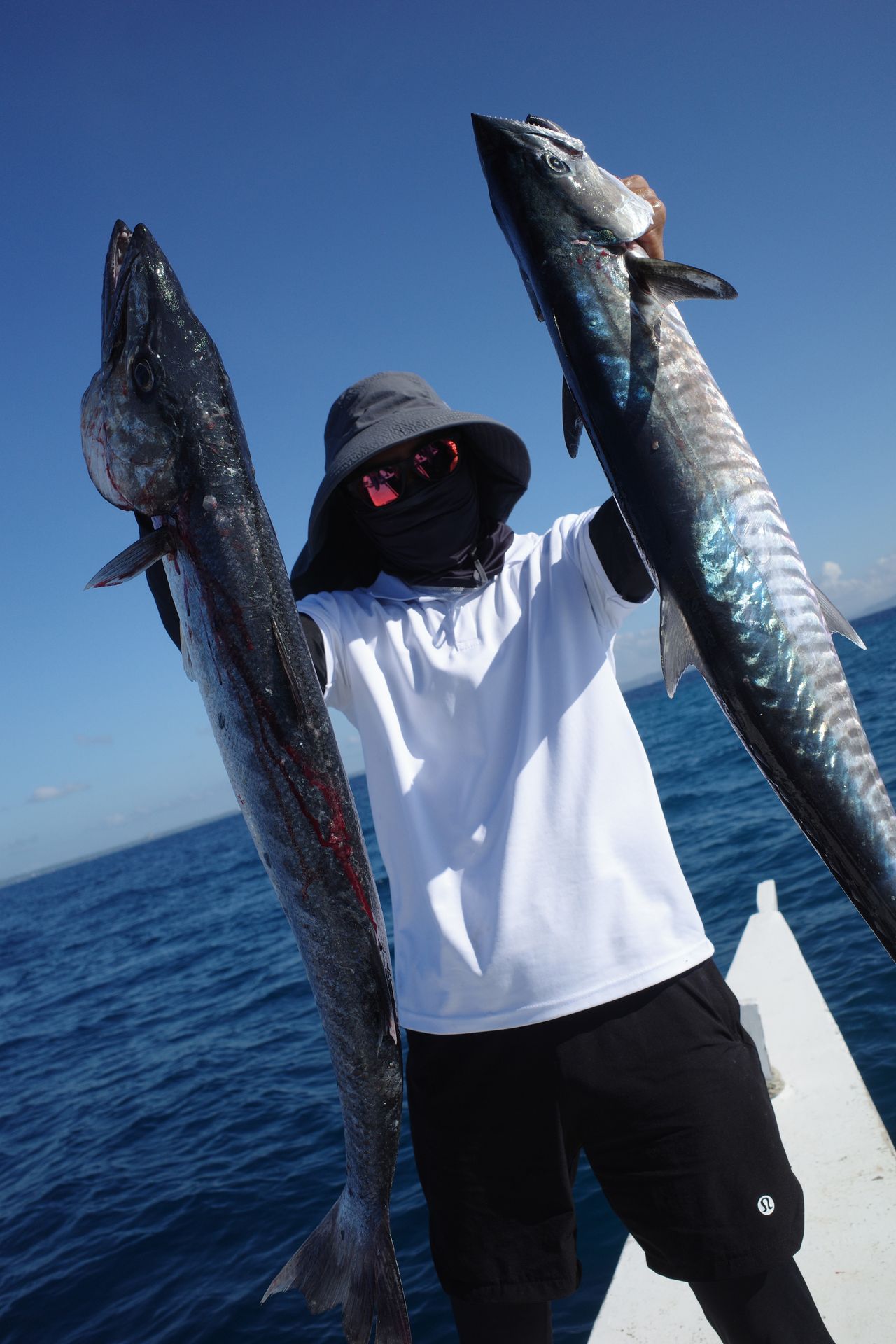 An angler holding two large fish.