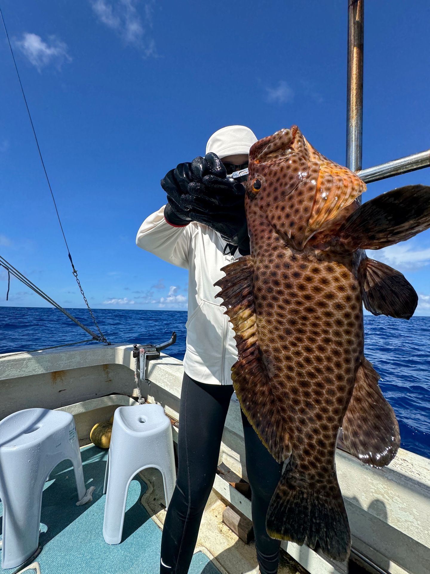 An angler holding his large catch on the boat